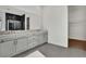 Double vanity bathroom with grey cabinets and walk-in closet at 2605 Waterfront Cir, Sarasota, FL 34240
