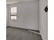 Simple bedroom with grey carpet and window overlooking a lake at 2605 Waterfront Cir, Sarasota, FL 34240