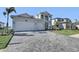 Two-story house with gray paver driveway and landscaped lawn at 2605 Waterfront Cir, Sarasota, FL 34240