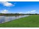 Serene lake view featuring a tranquil waterfront and green grass at 2605 Waterfront Cir, Sarasota, FL 34240