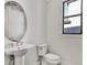 Powder room with pedestal sink and oval mirror at 2605 Waterfront Cir, Sarasota, FL 34240