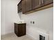 Laundry room with dark brown cabinets and a utility sink at 2625 Waterfront Cir, Sarasota, FL 34240