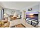 Living room with large TV, comfortable seating, and tiled floors at 6157 Midnight Pass Rd # E24, Sarasota, FL 34242