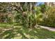 Landscaped yard with a gravel driveway and tropical plants at 3301 Bay Shore Rd, Sarasota, FL 34234