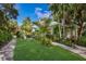 White bungalow with tropical landscaping and seating area at 3301 Bay Shore Rd, Sarasota, FL 34234