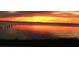 Fiery sunset over calm water with pilings at 3301 Bay Shore Rd, Sarasota, FL 34234