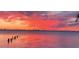 Pink and red sunset over the water with pilings at 3301 Bay Shore Rd, Sarasota, FL 34234