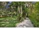 Gravel driveway shaded by large oak and palm trees at 3301 Bay Shore Rd, Sarasota, FL 34234