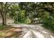 Gravel driveway leading to home, shaded by large trees at 3301 Bay Shore Rd, Sarasota, FL 34234