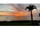 Sunset over the water with palm trees and pilings at 3301 Bay Shore Rd, Sarasota, FL 34234