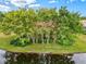 Waterfront property with lush landscaping and mature trees at 10115 Day Lily Ct, Bradenton, FL 34212