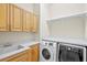Laundry room with washer, dryer, and wood cabinets at 10115 Day Lily Ct, Bradenton, FL 34212