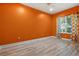 Bedroom with orange walls and light wood flooring at 10115 Day Lily Ct, Bradenton, FL 34212
