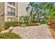 Brick pathway with lush landscaping and a stone bench at 6157 Midnight Pass Rd # E24, Sarasota, FL 34242