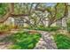 Brick pathway meanders through lush landscaping and mature trees at 6157 Midnight Pass Rd # E24, Sarasota, FL 34242