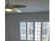 This bright bedroom boasts a modern ceiling fan and plantation shutters for adjustable natural light at 220 Santa Maria St # 240, Venice, FL 34285