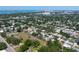Wide aerial shot of a modern home with a pool, nestled within a green neighborhood with city views on the horizon at 2226 Grove St, Sarasota, FL 34239