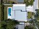 Aerial view of a modern home showcasing a backyard pool, patio, and driveway in a serene neighborhood at 2226 Grove St, Sarasota, FL 34239