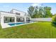 Expansive backyard with pristine lawn, modern outdoor kitchen, covered patio, and sparkling pool perfect for outdoor enjoyment at 2226 Grove St, Sarasota, FL 34239