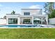 Beautiful backyard with modern white fence, lush lawn, inviting pool, covered patio, and outdoor grill at 2226 Grove St, Sarasota, FL 34239