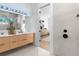 Contemporary bathroom boasts a double vanity, wood cabinets, and a view into the bedroom at 2226 Grove St, Sarasota, FL 34239