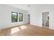 Bright bedroom featuring hardwood floors, black framed windows, and a door leading to the ensuite bathroom at 2226 Grove St, Sarasota, FL 34239