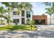 Beautifully landscaped home with modern architecture, bright lawn, and a sleek, black garage door at 2226 Grove St, Sarasota, FL 34239