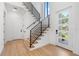 Open foyer area with hardwood floors and a modern staircase with black metal railing at 2226 Grove St, Sarasota, FL 34239