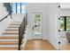 Bright foyer showcasing a modern staircase, hardwood floors, and a glass-paneled front door at 2226 Grove St, Sarasota, FL 34239