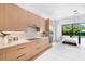 Stylish kitchen with wood cabinets, marble countertops, and a view of the backyard pool at 2226 Grove St, Sarasota, FL 34239