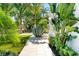 Lush landscaping with palm trees, agave, and pavers leading to a bright white home at 2226 Grove St, Sarasota, FL 34239