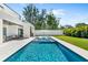 Large outdoor pool with lounge chairs, an umbrella, an outdoor kitchen, and a covered patio with ample space for relaxation at 2226 Grove St, Sarasota, FL 34239