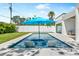 Backyard pool with tanning chairs and sun umbrella offering a private space for relaxation and outdoor enjoyment at 2226 Grove St, Sarasota, FL 34239