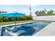 Relaxing pool area featuring a sun umbrella, tanning chairs, and a sparkling jacuzzi, perfect for outdoor enjoyment at 2226 Grove St, Sarasota, FL 34239