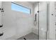 Elegant frameless shower with gray tile, built-in bench, and black fixtures under a bright window at 2226 Grove St, Sarasota, FL 34239