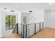 Modern staircase with sleek metal railing, hardwood floors, and stylish hanging pendant lights at 2226 Grove St, Sarasota, FL 34239