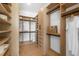 Spacious walk-in closet with wood shelving, drawers, and ample hanging space for organized storage at 2226 Grove St, Sarasota, FL 34239
