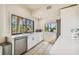 Modern kitchen with white cabinets, stainless steel appliances, and water views at 7147 La Lenaire Dr, Longboat Key, FL 34228