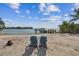 Peaceful waterfront view with beach access and chairs at 7147 La Lenaire Dr, Longboat Key, FL 34228