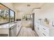 Modern kitchen with white cabinets, stainless steel appliances, and water views at 7147 La Lenaire Dr, Longboat Key, FL 34228