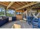 Covered outdoor kitchen and dining area with grill, TV, and seating at 7147 La Lenaire Dr, Longboat Key, FL 34228