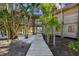 Wooden walkway through lush tropical landscaping towards home entrance at 7147 La Lenaire Dr, Longboat Key, FL 34228