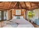 Cozy bedroom with wood-beamed ceiling, large bed, and access to a balcony at 7147 La Lenaire Dr, Longboat Key, FL 34228