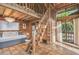 Charming bedroom with wooden loft and tiled floors, featuring a daybed and staircase at 7147 La Lenaire Dr, Longboat Key, FL 34228