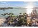 Aerial view of waterfront home with private beach, boat dock and lush landscaping at 7147 La Lenaire Dr, Longboat Key, FL 34228
