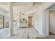 Light and airy hallway with white walls, wood-look floors, and access to other rooms at 7147 La Lenaire Dr, Longboat Key, FL 34228