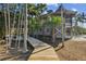Elevated walkway leading to a stunning waterfront home with tropical landscaping at 7147 La Lenaire Dr, Longboat Key, FL 34228