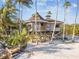 Elevated home on stilts with private beach access and tropical landscaping at 7147 La Lenaire Dr, Longboat Key, FL 34228