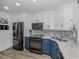 Modern kitchen with blue cabinets, granite countertops, and stainless steel appliances at 220 Santa Maria St # 240, Venice, FL 34285