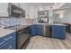 Updated kitchen featuring blue cabinetry, granite countertops, and stainless steel appliances at 220 Santa Maria St # 240, Venice, FL 34285